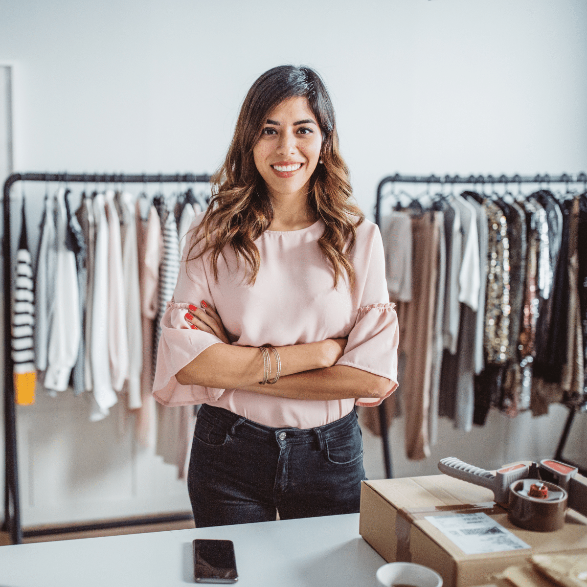 Retail store owner standing at a counter surrounded by clothing racks, emphasizing Zoku's warehouse and inventory management.