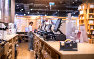 Retail store POS machines with blurry cashier staff.
