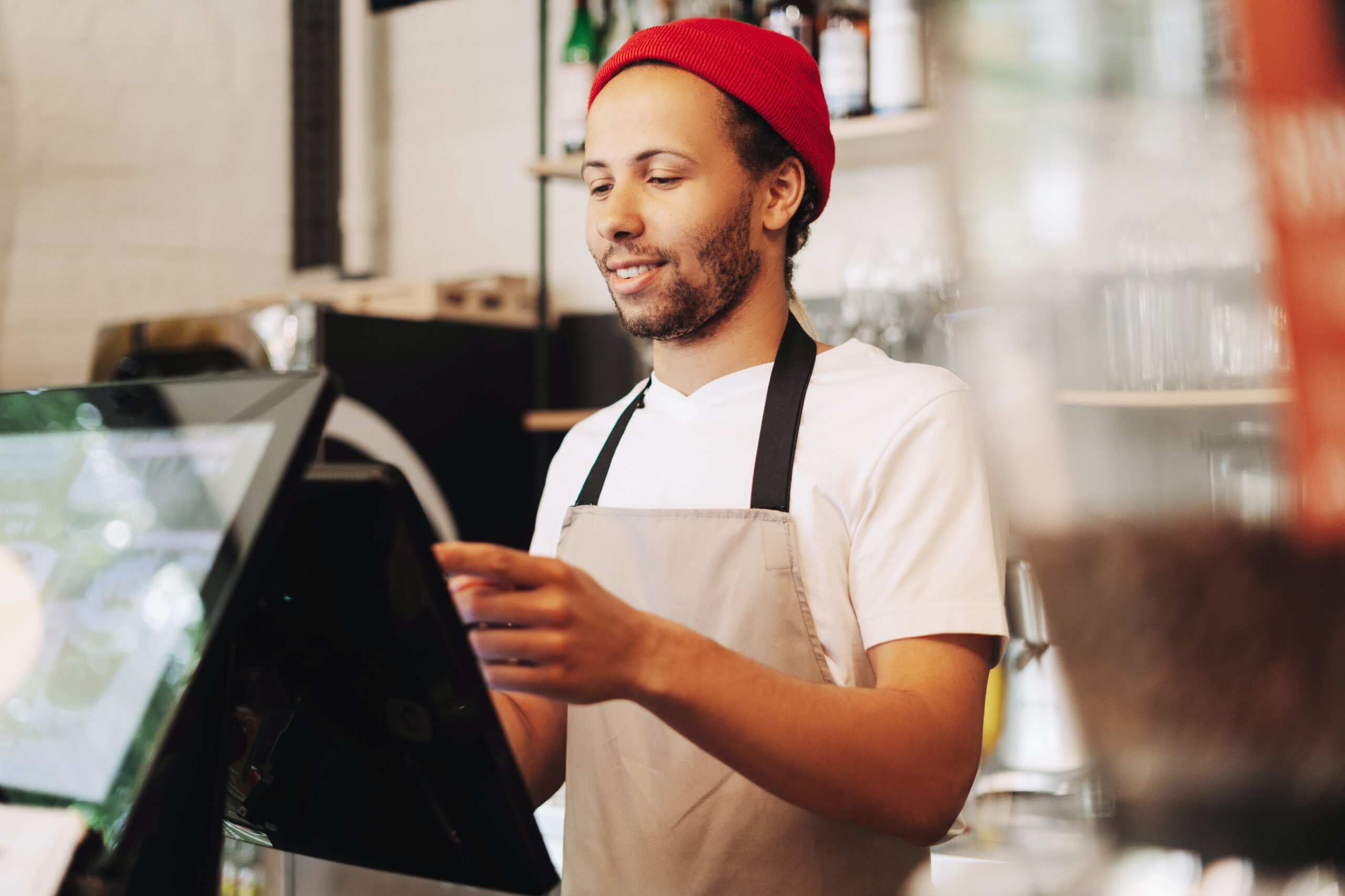 Barista taking an order taking order on digital pos system.